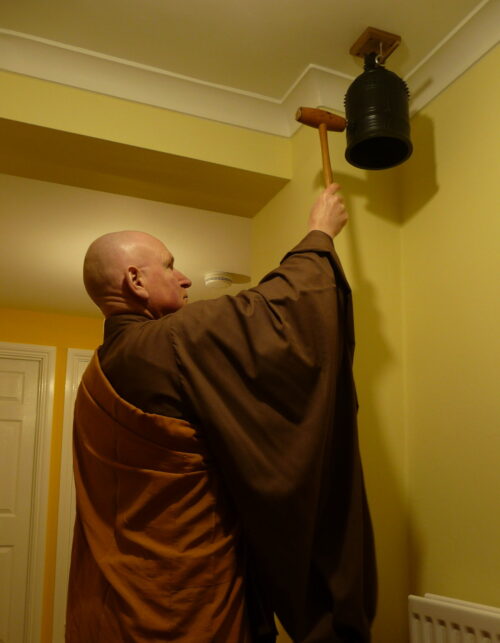 Rev. Aiden striking the temple bell